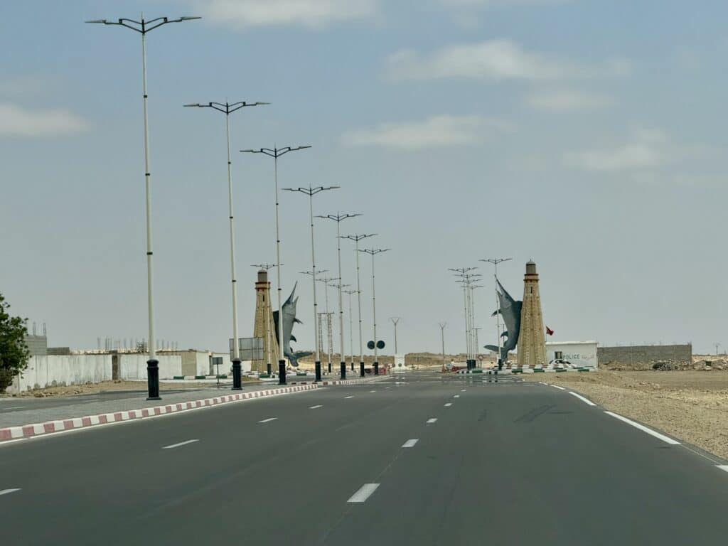 Entrada a la ciudad de Boujdour con esculturas de peces espada y faros a ambos lados de la carretera N1