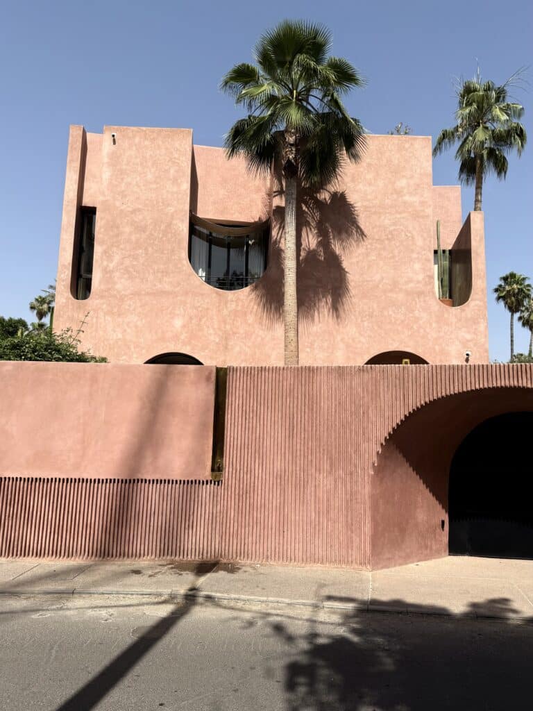fachada contemporánea rosa con acabado tipo tadelakt en marruecos, palmeras y diseño minimalista