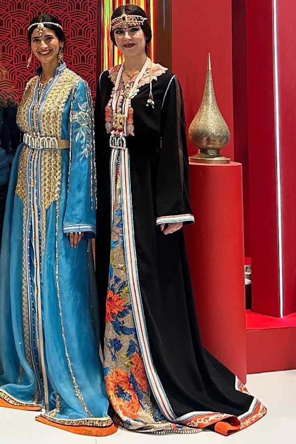 Dos mujeres vestidas con takchitas bordadas, traje ceremonial tradicional marroquí, en un entorno festivo